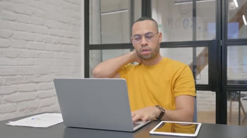 Adult Man Types at Laptop, Stretches Neck
