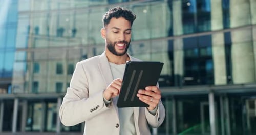 Young Man Using Tablet Outside Modern Building
