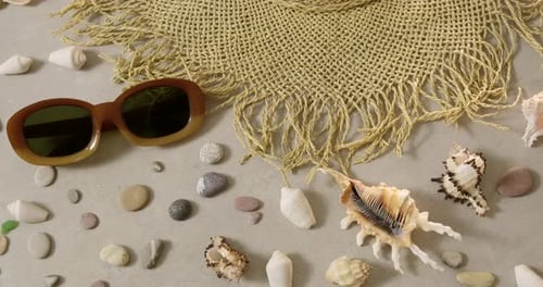 Travel summer accessories - female straw hat and sunglasses lie on beach sand