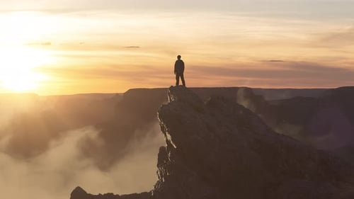 Epic Adventure Composite of Man Hiker on Top of a Rocky Mountain