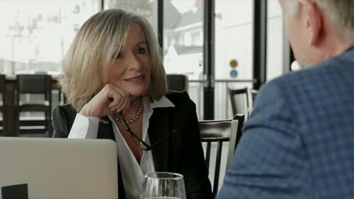 Business people engage in lively discussion during lunch meeting at restaurant