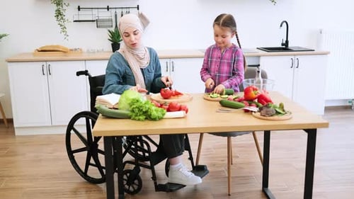 Woman in Wheelchair Cooking with Child in Kitchen