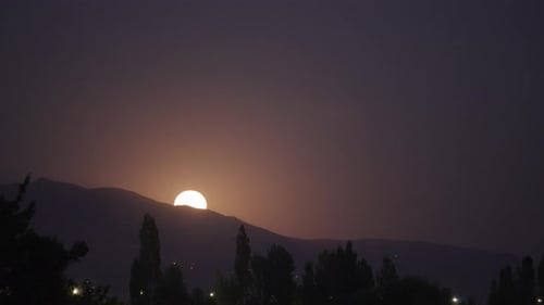 Super moon rising behind a mountain