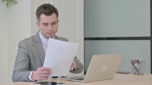 Young Adult Typing at Desk in Modern Office