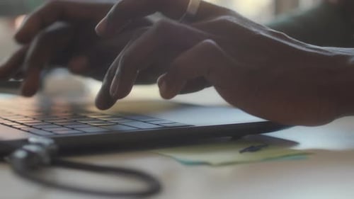Hands of Man Typing on Laptop Keyboard at Office Workplace