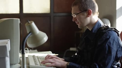 Policial com óculos inserindo informações no computador HD