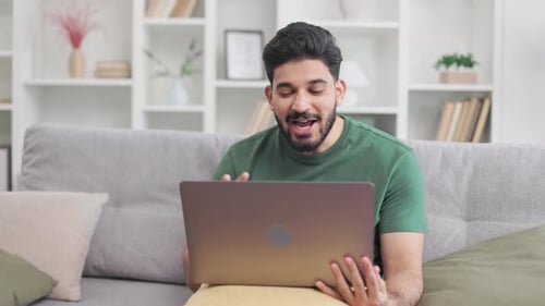 Man On Couch Video Conferencing on Laptop