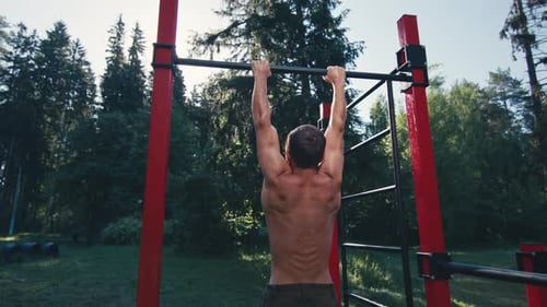 Workout in the park. Young caucasian man with lean body works out in the park