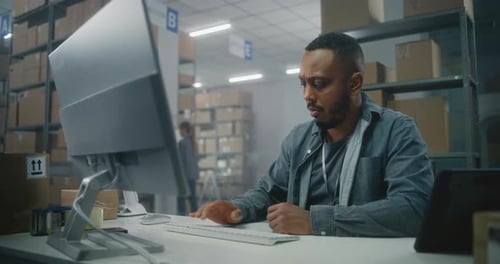 African American Logistics Specialist Works on Computer Female Inventory Clerk Scans Code on Parcel