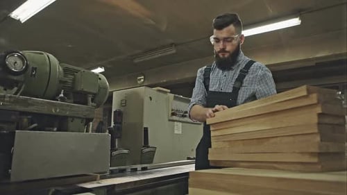 Man Using Woodworking Equipment in Workshop