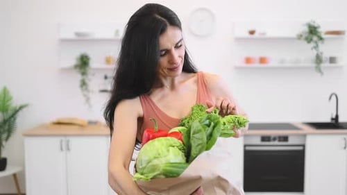 Fit Lady Posing at Home with Bag of Greens and Vegetables
