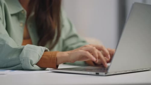 Woman Typing on Silver Laptop in Office