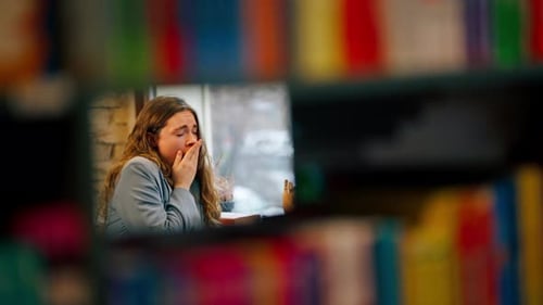 Close Up in Bookstore Near Window a Beautiful Student is Sitting Boring Reading Books Preparing for