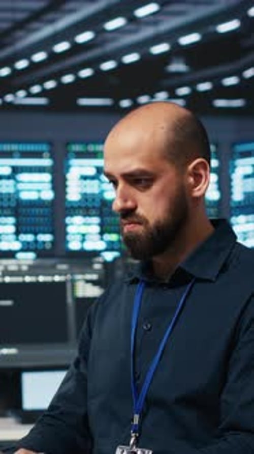 Man Working in Dark Server Room on Computer