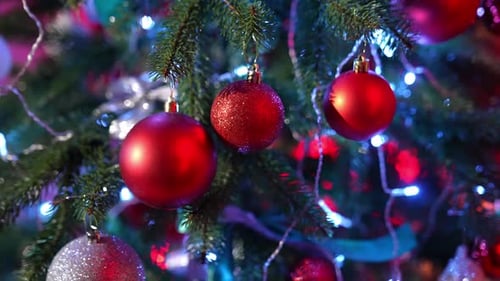Christmas tree. Beautiful New year fir tree with bright Christmas balls and ribbons. Close-up.