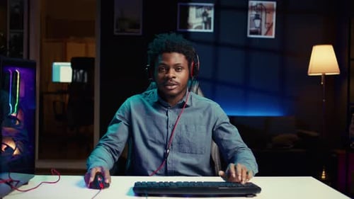 Young Adult with Headphones Using Computer at Night