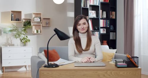 Young Adult Woman Smiling at Desk at Home