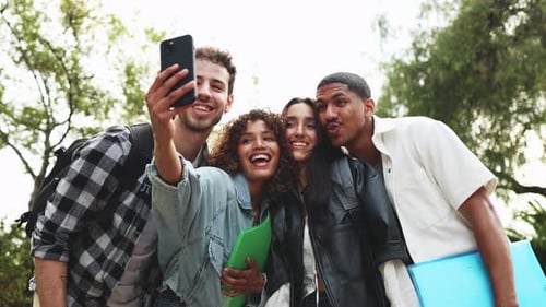 College students taking joyful selfie in park