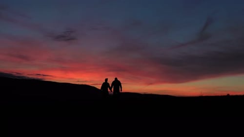 Silhouette Couple standing on a mountain sunset