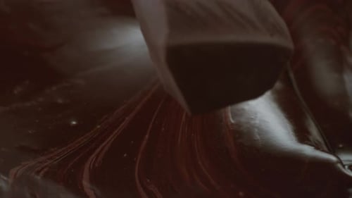 Piece of Chocolate Dropping Into Melted Chocolate