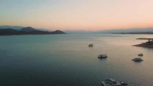 Aerial drone flying over a lake, water dam, with mountains at sunrise. Beautifull dreamy landscape v