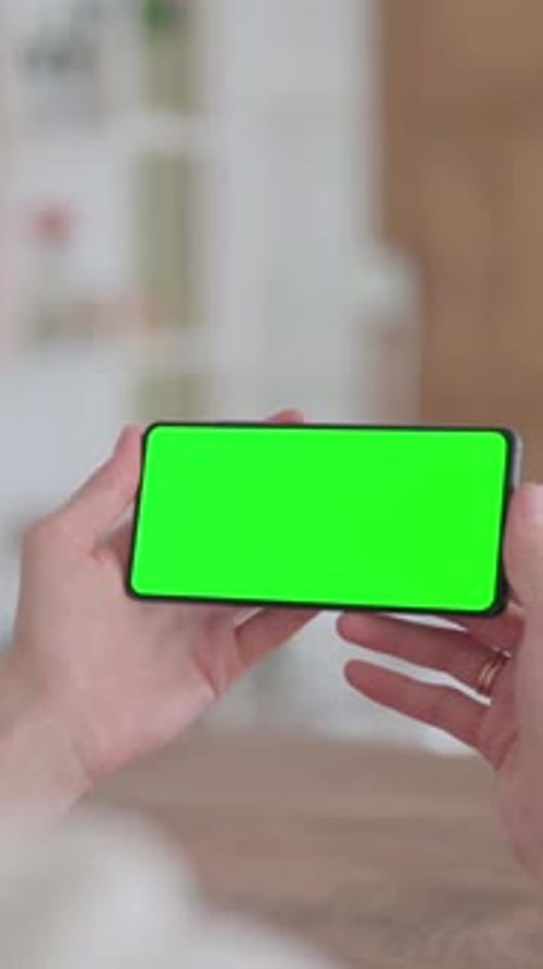 Rear View of Woman Holding Smartphone with Green Chroma Screen, Vertical Video