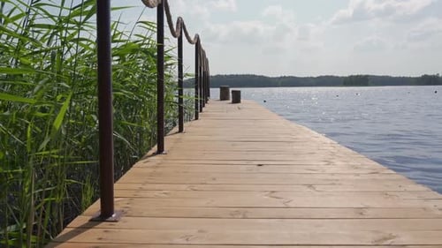 Langsam über einen großen Holzsteg in einen See gehen