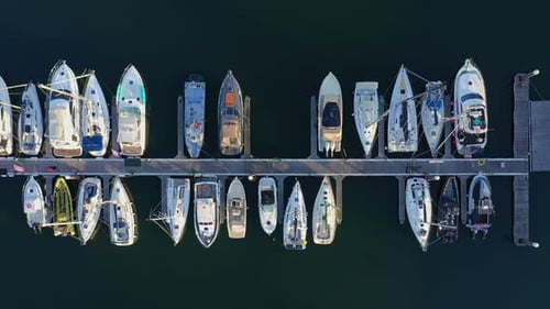 Aerial Top Down View of a Row of Yachts in Marina with Moored Sailboats