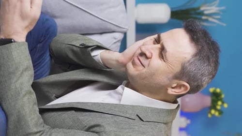 Man Lying on Couch Using Mobile Phone Indoors