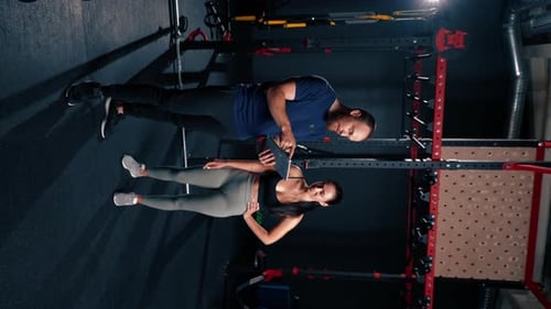 Woman and Trainer in Gym Looking at Tablet