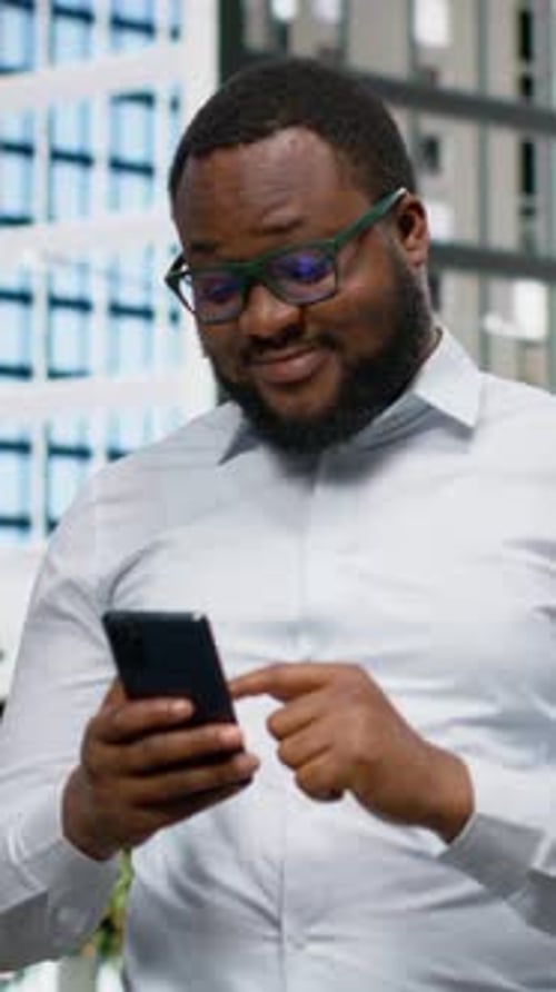 Vertical Video Confident Black Man Texting Messages on Mobile Phone in the City Center