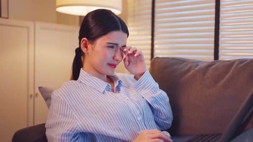 Woman Typing on Laptop in Warmly Lit Apartment