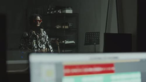 Black Musician in Headphones Singing into Microphone in Recording Booth