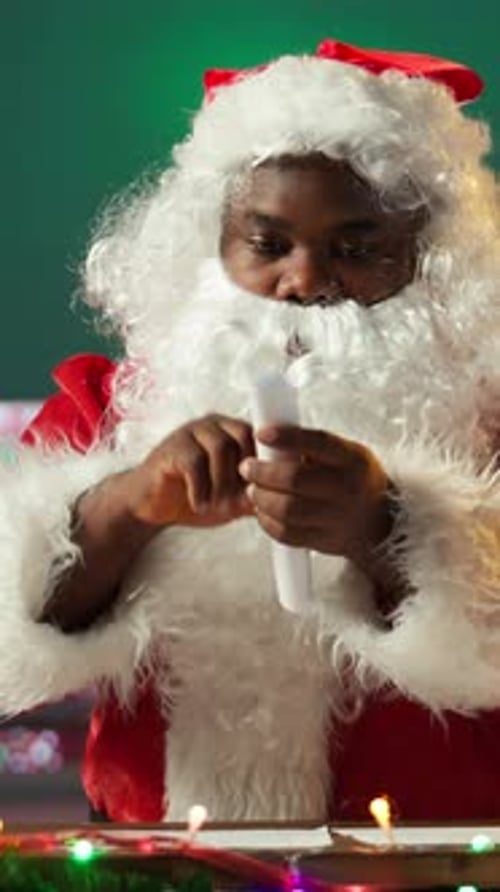 Santa Reading Letter at Decorated Christmas Table