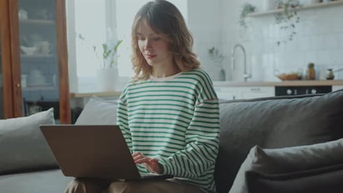 Woman Working on Laptop Computer in Modern Apartment