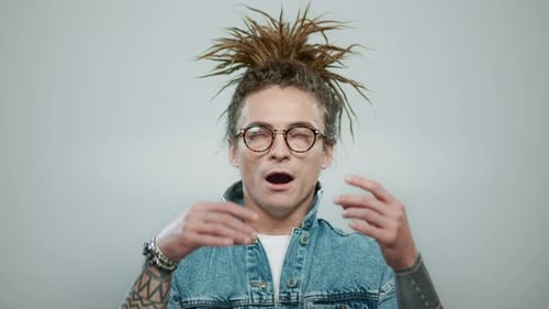Portrait of Stylish Man Meditating on Grey Background. Closeup Tattooed Guy Showing