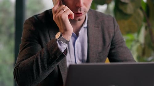 a serious man a businessman works at a laptop in the office communicates with colleagues