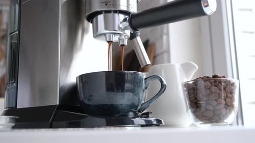 männliche Hände halten Siebträger in der Hand und kochen zu Hause frischen aromatischen Kaffee