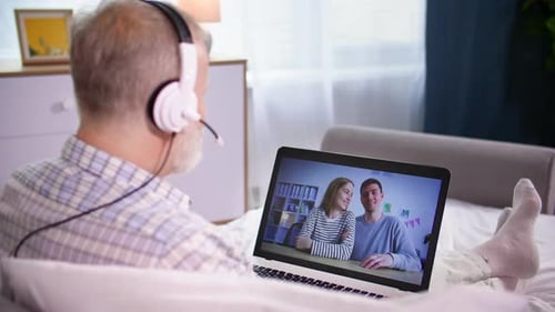 Senior Adult Video Calling Young Couple on Laptop