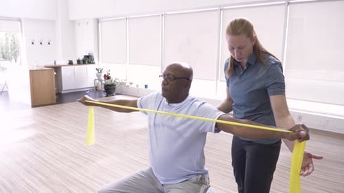 Senior Man Using Resistance Band with Physical Therapist