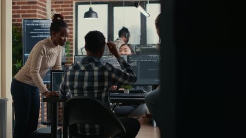 Software Development Team Reviews Coding Project at Development Workstation with Multiple Monitors