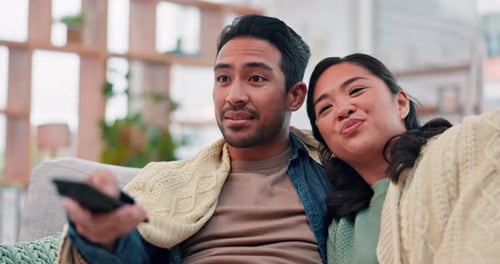 Young Couple Watching Television at Home on Couch