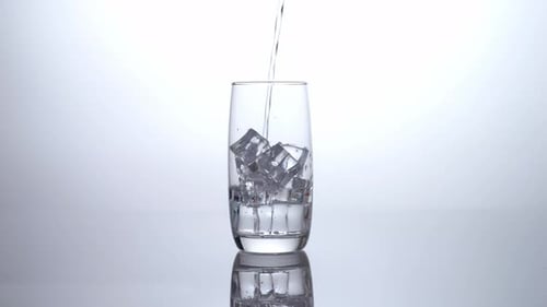 Water Pouring Over Ice into a Glass
