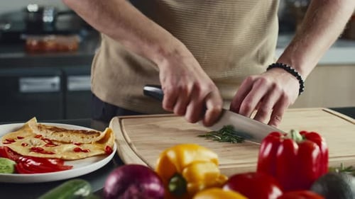Man Chopping Green Onion and Adding to Omelet