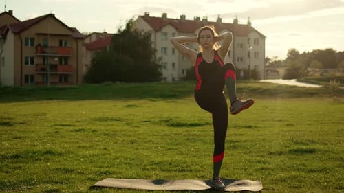 Woman Exercising Outdoors at Sunset on Yoga Mat