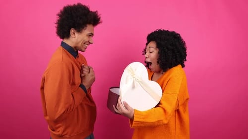 Excited Woman Receives Heart Gift from Smiling Man