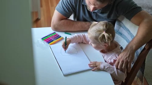 Father and Daughter Drawing Together at the Table