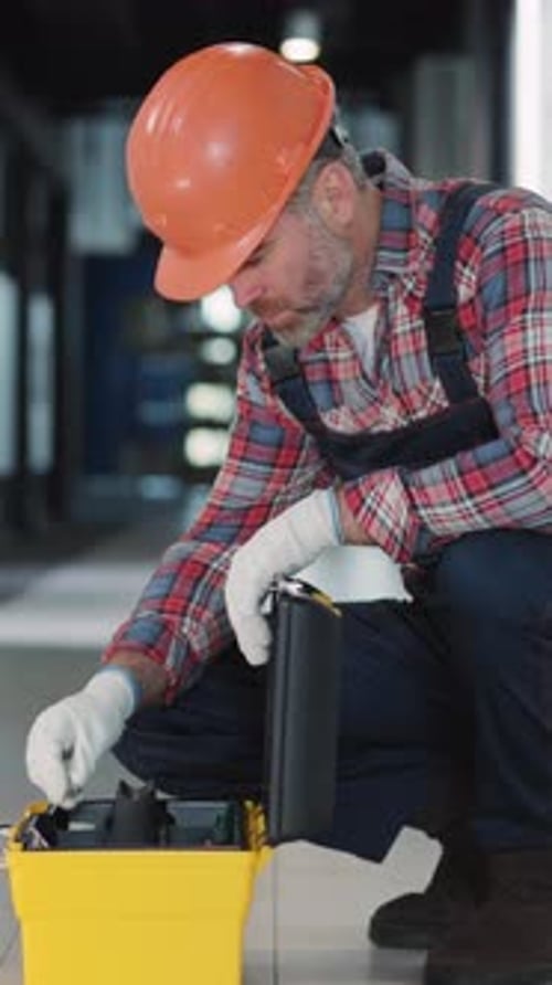 A Construction Worker Using a Toolbox Effectively on a Work Site to Complete Tasks