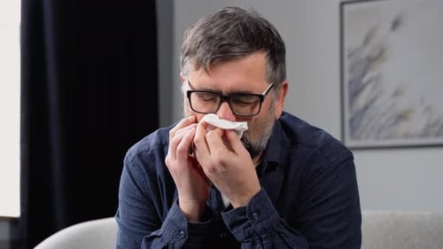 Adult Man Using a Tissue Indoors