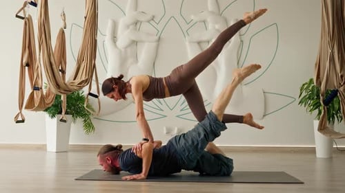 couple man and woman doing yoga exercises together lying on the floor in the gym for training